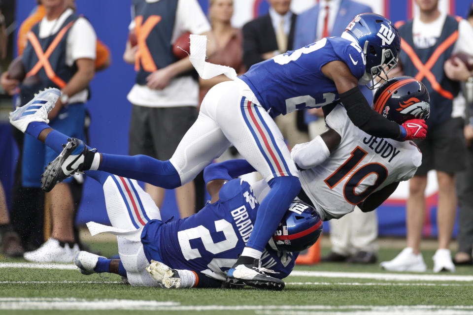 Denver Broncos wide receiver Jerry Jeudy (10) is tackled by New York Giants' Logan Ryan (23) and James Bradberry (24) during the second half of an NFL football game Sunday, Sept. 12, 2021, in East Rutherford, N.J. (AP Photo/Adam Hunger)