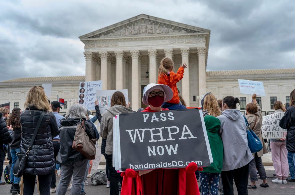 Abortion-rights protesters display placards, urging lawmakers to pass the Women's Health Protection Act, during a demonstration outside of the U.S. Supreme Court, Sunday, May 8, 2022, in Washington.