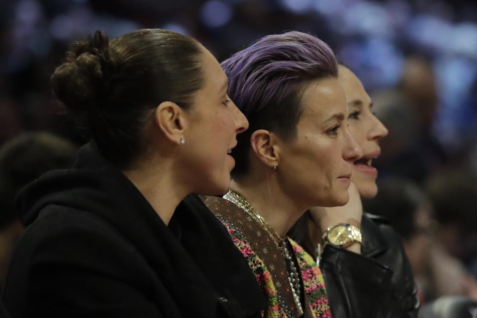 Basketball player Diana Taurasi, soccer player Megan Rapinoe and basketball player Sue Bird, from left, are seen during the second half of the NBA All-Star basketball game Sunday, Feb. 16, 2020, in Chicago. (AP Photo/Nam Huh)