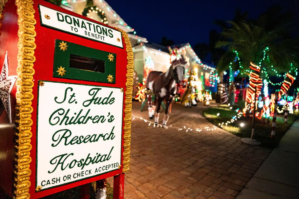 A donation box sits outside of the home of Ron Spering next to his decorations in Marco Island on Wednesday, Dec. 6, 2023. Last year, he raised approximately $23,000.