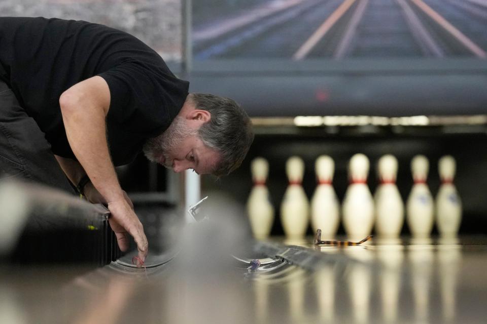 Lucas Mitchum inspects the gutters on a lane at Just In Time Recreation, Wednesday, May 1, 2024, in Lewiston, Maine. The bowling alley was scheduled to reopen Friday, May 3, seven months after Maines deadliest mass shooting. (AP Photo/Robert F. Bukaty)