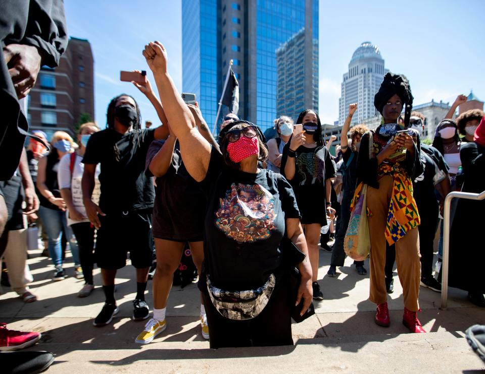 Rhonda Mathies, 69, of Louisville, gets down on her knees as she sings "We Shall Overcome" along with the crowd Sunday, May 31, 2020, during a Black Lives Matter healing rally in front of KFC Yum! Center in downtown Louisville.