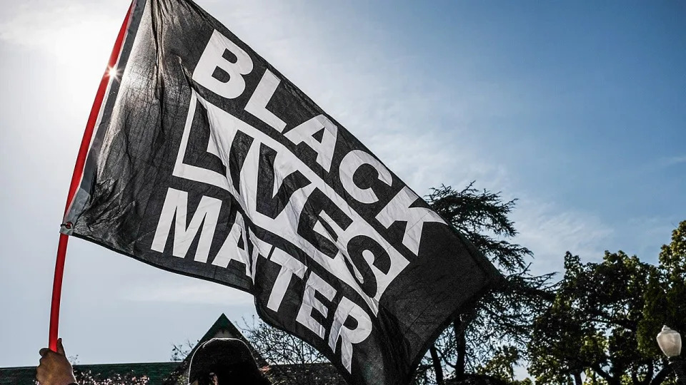 A protester waves a Black Lives Matter flag. BLM paid $970,000 to Trap Heals LLC, a company established by Damon Turner, the father of Cullors' child, and $840,000 to Cullors Protection LLC, a security firm owned by her brother, Paul Cullors, tax forms show. <span class="copyright">Getty Images</span>