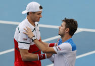 John Isner, left, of the U.S. shakes hands with Switzerland's Stan Wawrinka after retiring from their third round match at the Australian Open tennis championship in Melbourne, Australia, Saturday, Jan. 25, 2020. (AP Photo/Andy Wong)