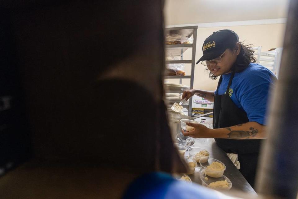 Nupohn Inthanousay, uno de los cinco propietarios de Goldee's Barbecue, prepara porciones de arroz glutinoso para el postre de arroz glutinoso con mango para el servicio antes de la apertura en su ubicación en Fort Worth el viernes 28 de junio de 2024.
