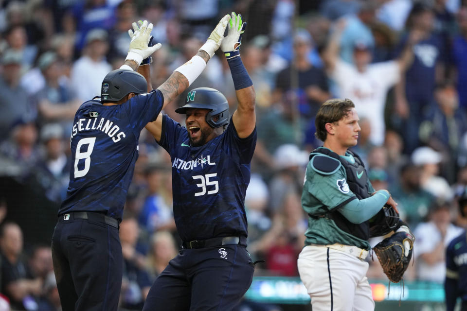 National League's Elias Díaz, of the Colorado Rockies (35), celebrates his two run home run with Nick Castellanos (8), of the Philadelphia Phillies, in the eighth inning during the MLB All-Star baseball game in Seattle, Tuesday, July 11, 2023. (AP Photo/Lindsey Wasson)