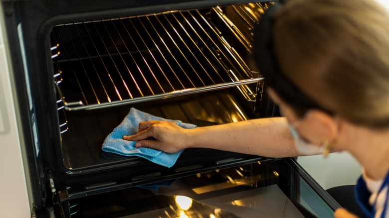 A person cleaning an oven