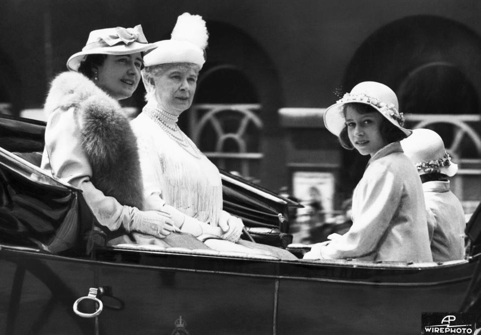 Two women and two girls ride in an open vehicle.