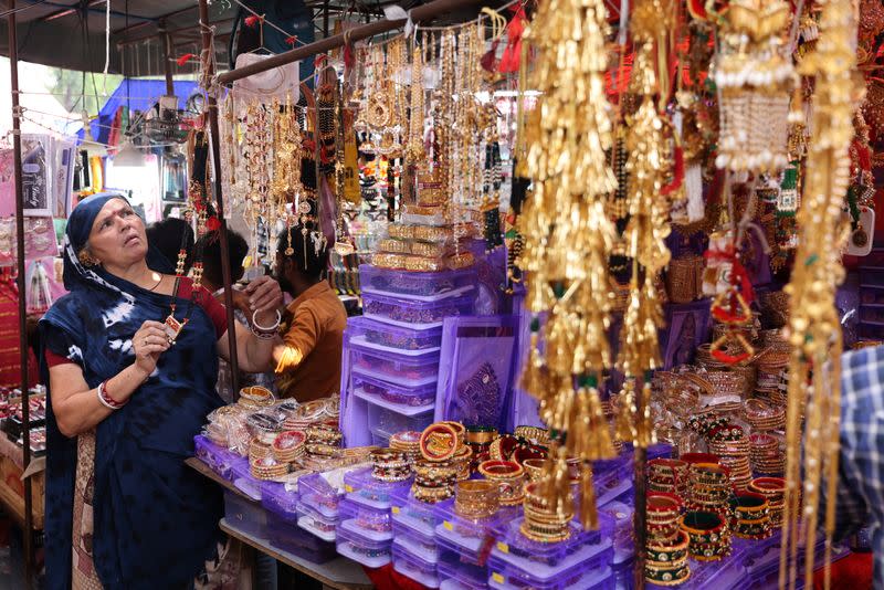 FILE PHOTO: Kamlaben Ashokbhai Patni adjusts imitation jewellery at a stall in a market in Ahmedabad