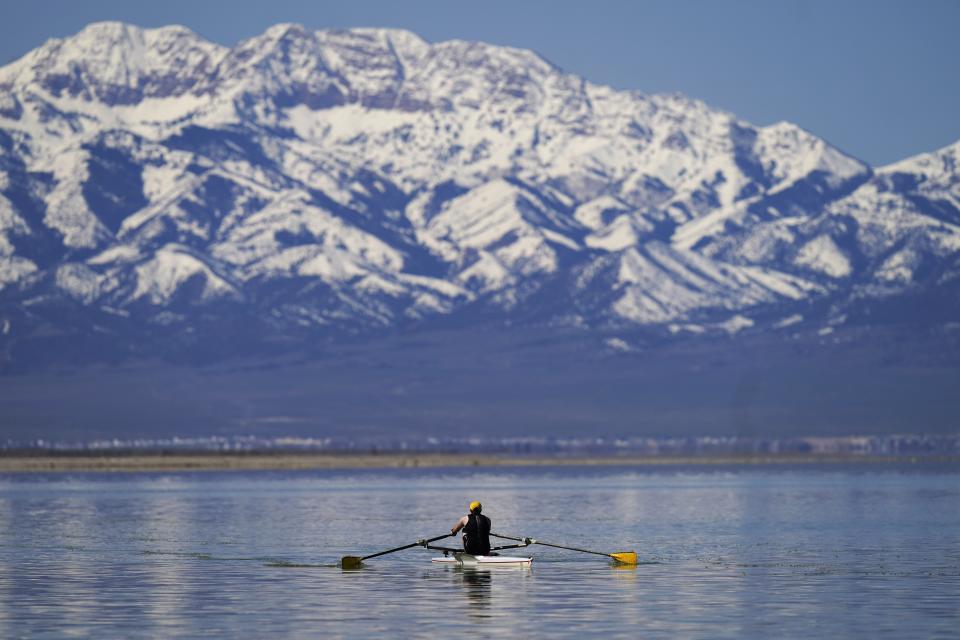A man rows on the Great Salt Lake on April 15, 2023, in Magna, Utah. Workers, hobbyists and residents who rely on the Great Salt Lake are rejoicing this year after winter's snow melted and led to a 6-foot rise at the lake. (AP Photo/Rick Bowmer)