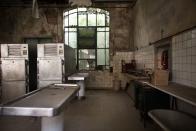 <p>A giant window, fit with cracked and shattered panes, overlooks this former autopsy room.</p>
