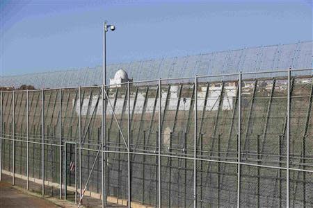 A mosque is seen behind the border fence which separates Morocco from Spain's north African enclave Melilla, seen from the Spanish territory December 3, 2013. REUTERS/Juan Medina