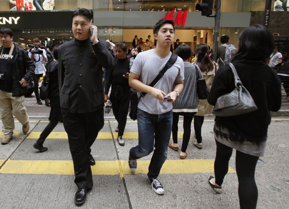 Howard talks on the mobile phone as he appears as a Kim Jong-un lookalike on a street at Hong Kong's Tsim Sha Tsui shopping district