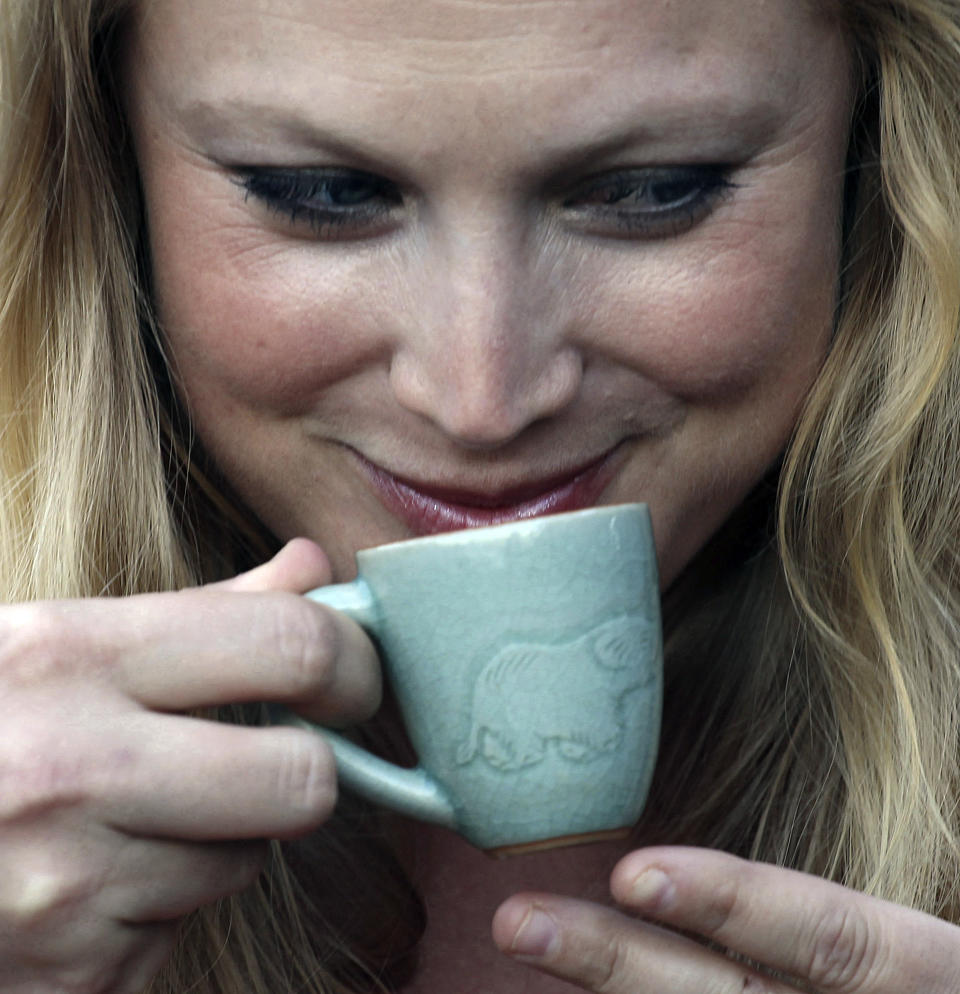 In this photo taken Dec. 3, 2012, Asleigh Nelson, 32, an American tourist from Tampa, Florida, tastes a cup of the $1,100 per kilogram ($500 per pound) Black Ivory coffee at a hotel restaurant in Chiang Rai province, northern Thailand. A Canadian entrepreneur with a background in civet coffee has teamed up with a herd of 20 elephants, gourmet roasters and one of the country's top hotels to produce the Black Ivory, a new blend from the hills of northern Thailand and the excrement of elephants which ranks among the world's most expensive cups of coffee. (AP Photo/Apichart Weerawong)