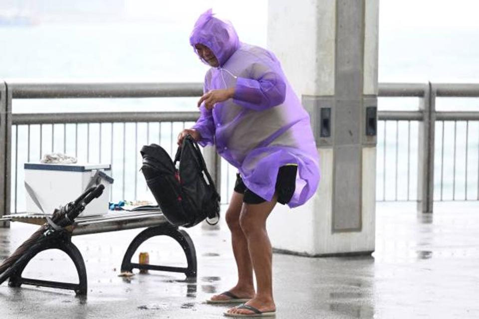 A man struggles with strong winds as Hong Kong hoisted typhoon signal no 8 (AFP via Getty Images)