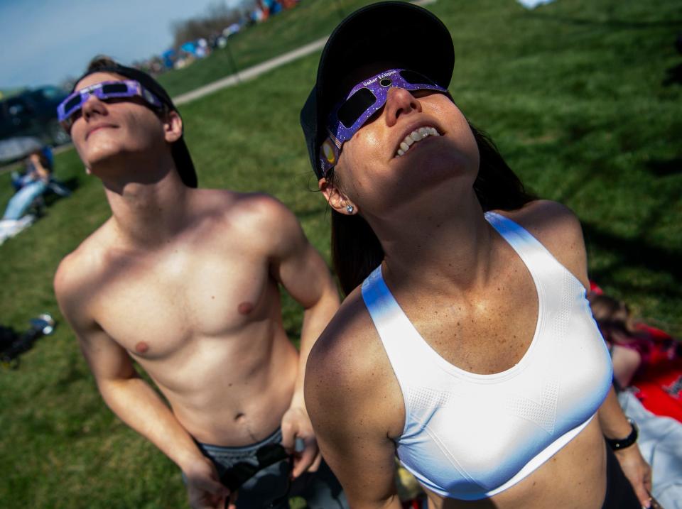 Colin Knox, left, and Cassie Knight, right, watch the eclipse at Switchyard Park on April 8, 2024.