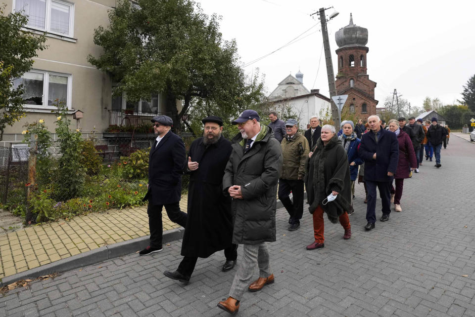 People walk together toward the place where some 60 Jews were executed during the Holocaust for the dedication of new memorial in Wojslawice, Poland, on Thursday Oct. 14, 2021. It is one of many mass grave sites to be discovered in recent years in Poland, which during World War II was occupied by Adolf Hitler’s forces. (AP Photo/Czarek Sokolowski)