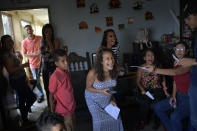 Ada Mendoza, 24, smiles during a game of riddles during her baby shower at her parents' apartment in the Catia neighborhood of Caracas, Venezuela, Saturday, Sept. 5, 2020. Mendoza has carried her baby amidst the coronavirus pandemic that has disrupted the lives of millions of Venezuelans, who since March 16th are still subject to a severe quarantine. (AP Photo/Matias Delacroix)