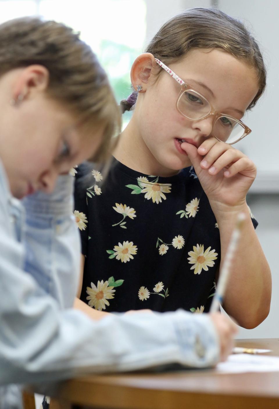 Nine-year-old Ana Browning watches Court Whisnant, 12, as they work to solve Challenge 2 during a STEAM Club event Monday morning at the Spangler Branch Library in Lawndale.