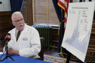 Dr. Lee Norman, top administrator at the Kansas Department of Health and Environment, uses a pointer to highlight a recent surge in coronavirus cases, Wednesday, July 1, 2020, at the Statehouse in Topeka, Kan. Norman is predicting that Kansas will see steeper increases in reported coronavirus cases. (AP Photo/John Hanna)