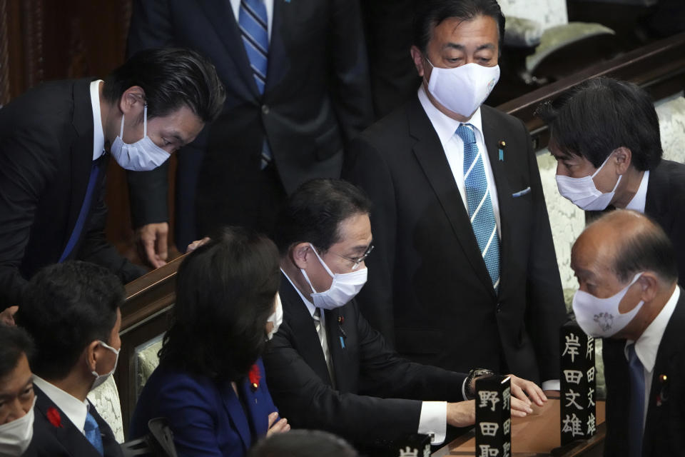 Japanese Prime Minister Fumio Kishida, center, and other lawmakers speak before dissolving the lower house, at an extraordinary Diet session at the lower house of parliament Thursday, Oct. 14, 2021, in Tokyo. Japan’s new Prime Minister Kishida dissolved the lower house of parliament Thursday, paving the way for Oct. 31 national elections.(AP Photo/Eugene Hoshiko)