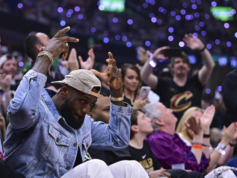 Los Angeles Lakers forward LeBron James, left, acknowledges the crowd during the first half of Game 4 of an NBA basketball second-round playoff series between the Cleveland Cavaliers and the Boston Celtics, Monday, May 13, 2024, in Cleveland. (AP Photo/David Dermer)