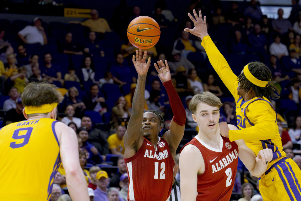 Alabama guard Latrell Wrightsell Jr. (12) shoots a three point basket against LSU guard Mike Williams III (2) as Alabama forward Grant Nelson (2) defends during the first half of an NCAA college basketball game in Baton Rouge, La., Saturday, Feb. 10, 2024. (AP Photo/Matthew Hinton)