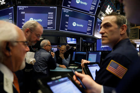 Traders await price updates of Spotify before the company's direct listing on the floor of the New York Stock Exchange in New York, U.S., April 3, 2018. REUTERS/Lucas Jackson