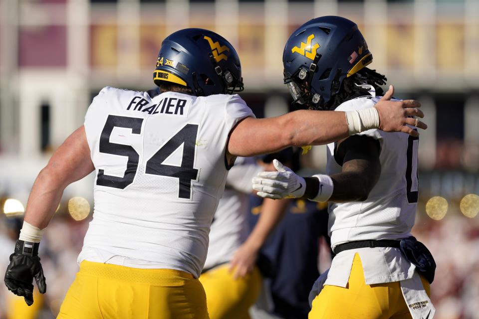 West Virginia wide receiver Bryce Ford-Wheaton (0) celebrates with teammates after catching a 25-yard touchdown pass during the first half of an NCAA college football game against Iowa State, Saturday, Nov. 5, 2022, in Ames, Iowa. (AP Photo/Charlie Neibergall)