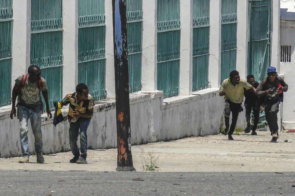 FILE - People run for cover as shots ring out near the National Palace, in Port-au-Prince, Haiti, April 30, 2024. Thousands across Haiti have fled their homes amid gang battles for control of areas of Port-au-Prince. (AP Photo/Ramon Espinosa, File)