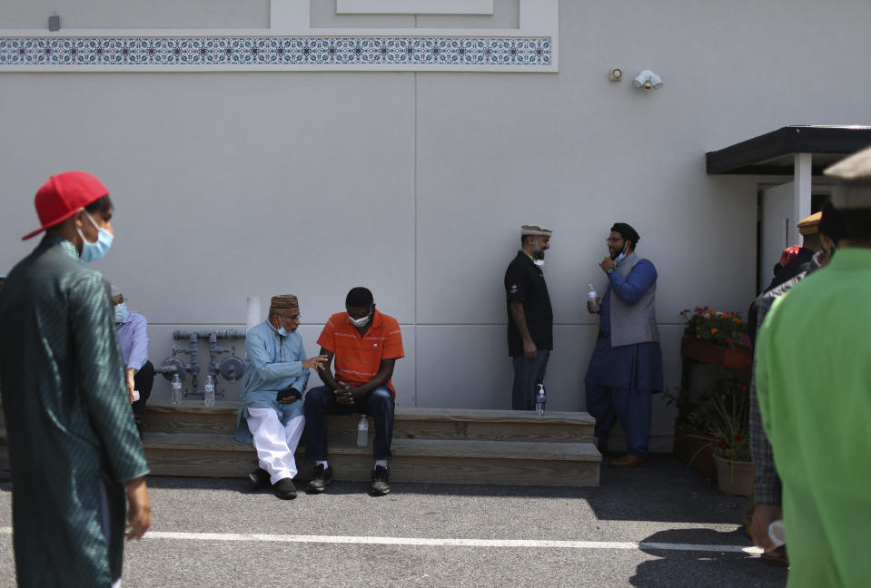 Community members talk outside of their local mosque in Rosedale, Md., after Friday prayer on Aug. 13, 2021. (AP Photo/Jessie Wardarski)
