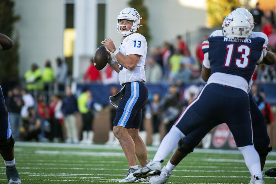 Old Dominion's Grant Wilson (13) looks to pass downfield while Liberty's Amari Williams rushes during the second half an NCAA college football game, Saturday, Nov. 11, 2023, in Lynchburg, Va. (AP Photo/Robert Simmons)