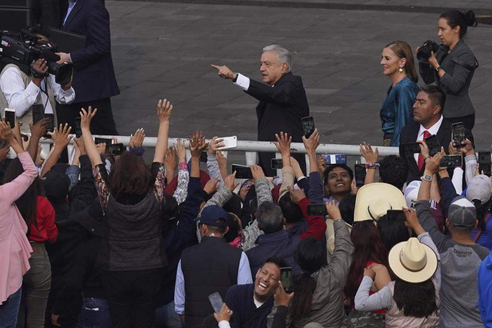 El presidente mexicano, Andrés Manuel López Obrador, acompañado por la primera dama Beatriz Gutiérrez, saluda a sus simpatizantes cuando llega para asistir a un mitin para conmemorar el 85 aniversario de la expropiación de la industria petrolera del país en 1938, en el Zócalo de la Ciudad de México, el sábado 18 de marzo. (Foto AP/Marco Ugarte)