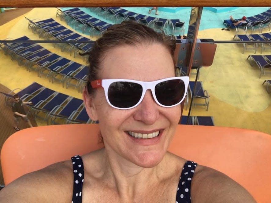 A picture of the writer lounging by the pool in sunglasses and a swimsuit