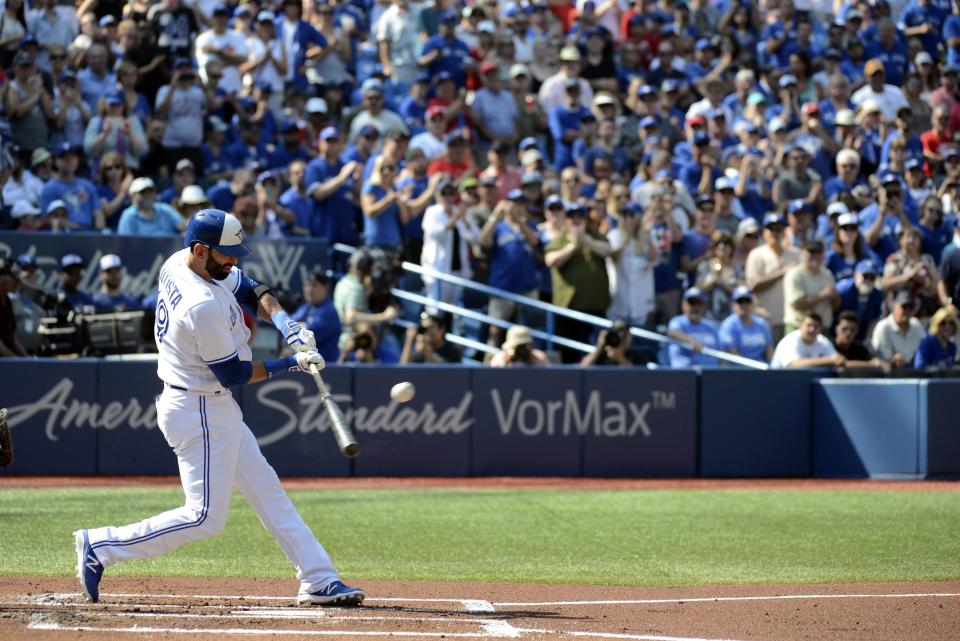 Toronto Blue Jays’ Jose Bautista hits a single in front of a crowd on their feet cheering him. (Jon Blacker/AP)