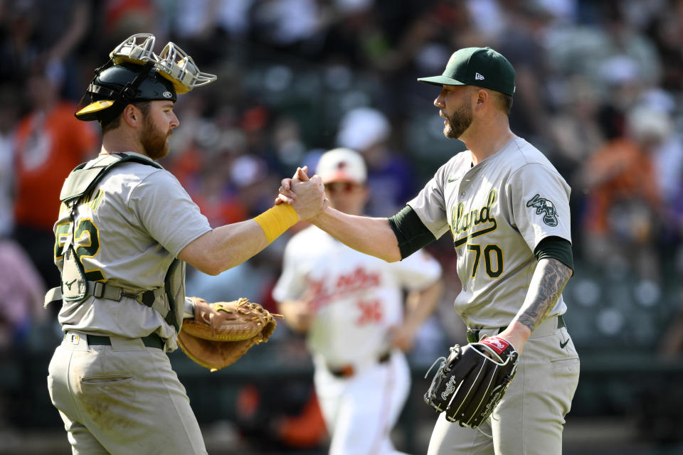Oakland Athletics relief pitcher Lucas Erceg (70) and catcher Kyle McCann (52) celebrate after a baseball game against the Baltimore Orioles, Sunday, April 28, 2024, in Baltimore. (AP Photo/Nick Wass)