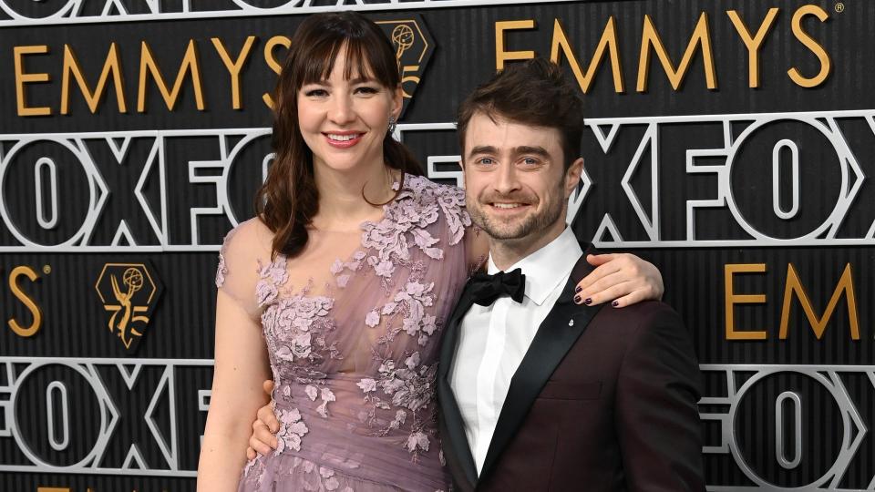  Daniel Radcliffe in black tux and Erin Darke in one shoulder purple tulle gown at 75th Primetime Emmy Awards