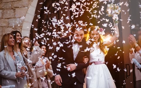 Happy bride and groom leaving church and celebrating - Credit: wundervisuals