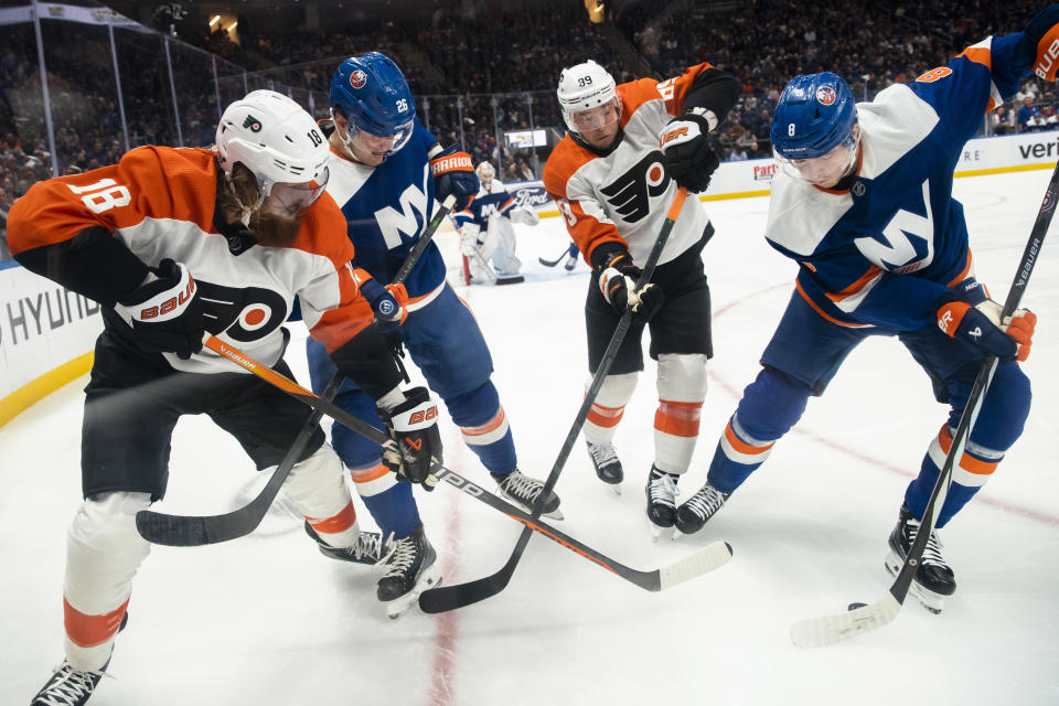 Philadelphia Flyers defenseman Marc Staal (18) and right wing Cam Atkinson (89) vie for control of the puck against New York Islanders right wing Oliver Wahlstrom (26) and defenseman Noah Dobson (8) during the first period of an NHL hockey game, Saturday, Nov. 25, 2023, in Elmont, N.Y. (AP Photo/Eduardo Munoz Alvarez)