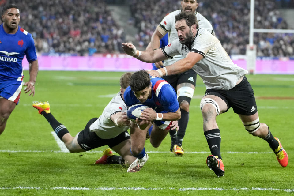 FILE - France's Roman Ntamack scores a try as he is tackled by New Zealand's Jordie Barrett and Sam Whitelock, right, during the international rugby union match between France and the All Blacks, at the Stade de France, in Saint Denis, north of Paris, Saturday, Nov. 20, 2021. (AP Photo/Christophe Ena, File)