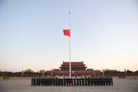 In this photo released by China's Xinhua News Agency, an honor guard stands in formation as a Chinese national flag flies at half-staff at Tiananmen Square in Beijing, Saturday, April 4, 2020. China plans to pause for 3 minutes of nationwide mourning on Saturday in rememberance of those who have died in the coronavirus outbreak. (Ju Huanzong/Xinhua via AP)