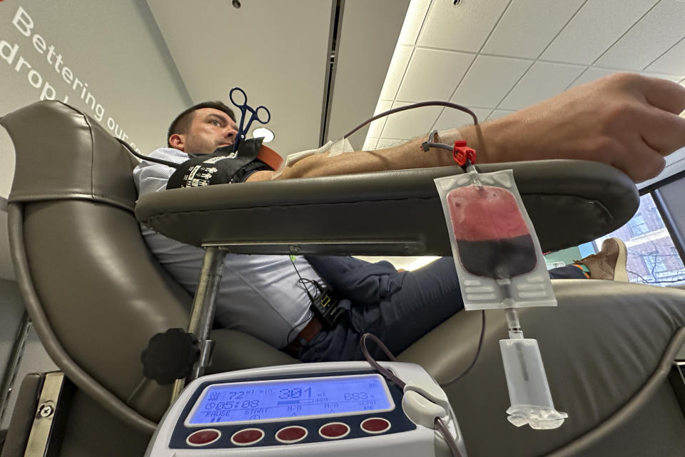 Aaron Posey, a Bloodworks Northwest executive, donates blood at the blood center's Seattle headquarters on Dec. 14, 2023. New federal guidelines that dropped an abstinence requirement before gay men in monogamous relationships can give blood are opening a new pool of potential donors. Posey, whose own life was saved by a transfusion when he fell down a set of stairs and broken glass sliced an artery, welcomed the new guidance, saying hospitals and patients need access to a new pool of donors. (AP Photo/Manuel Valdes)