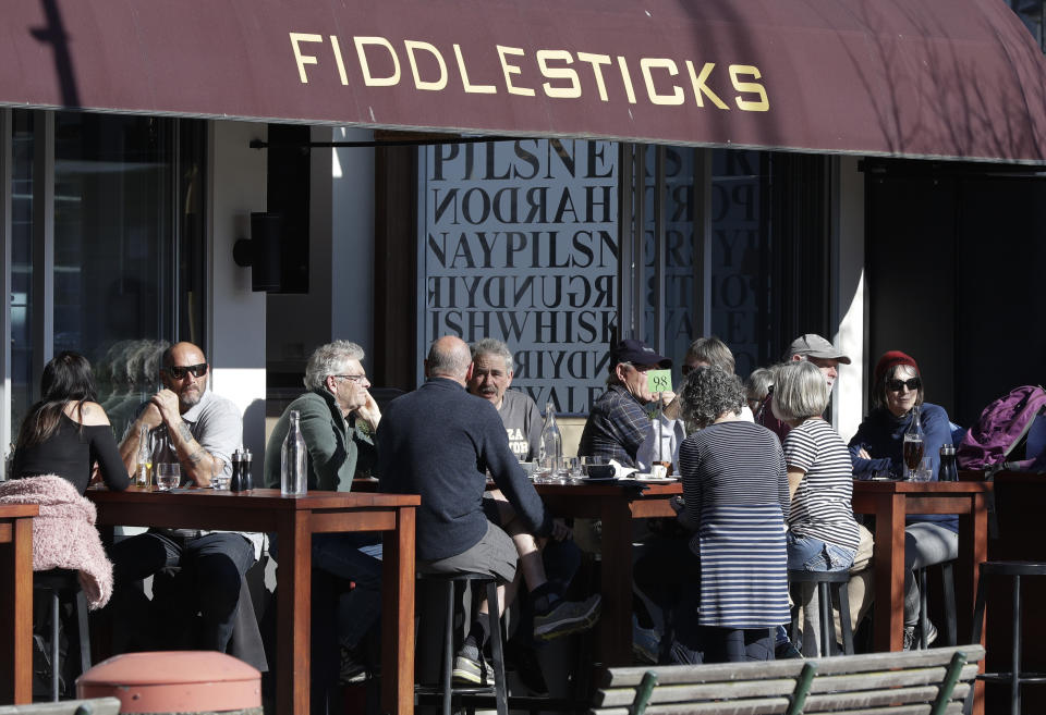 Customers at a cafe enjoy lunch in the sunshine in Christchurch, New Zealand, Sunday, Aug. 9, 2020. New Zealand marked a 100 days of being free from the coronavirus in its communities Sunday, Aug. 9, with just a handful of infections continuing to be picked up at the border where people are quarantined. (AP Photo/Mark Baker)