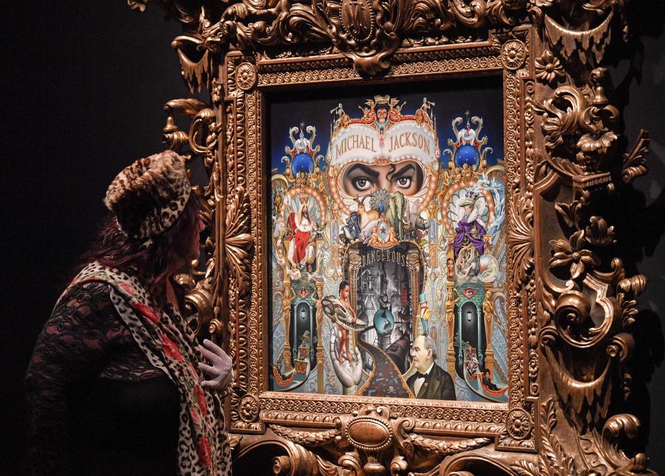 A visitor watches the picture 'The King Of Pop' from US artist Mark Ryden at a preview of the exhibition 'Michael Jackson: On The Wall' at the Bundeskunsthalle museum in Bonn, Germany, Thursday, March 21, 2019. The exhibition around the controversial iconic pop idol is open until July 14. (AP Photo/Martin Meissner)