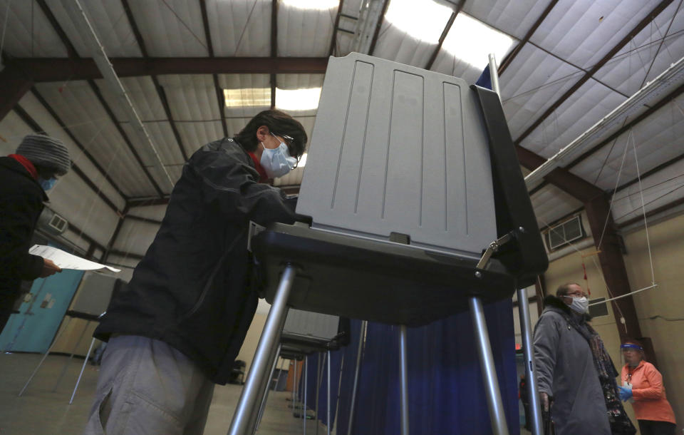 Sandy Martinez begins filling in the first in-person ballot of the day at an early voting center on Saturday, Oct. 17, 2020, in Santa Fe, N.M. Early voting centers opened Saturday across the state. In-person early voting extends for two weeks through Oct. 31. (AP Photo/Cedar Attanasio)