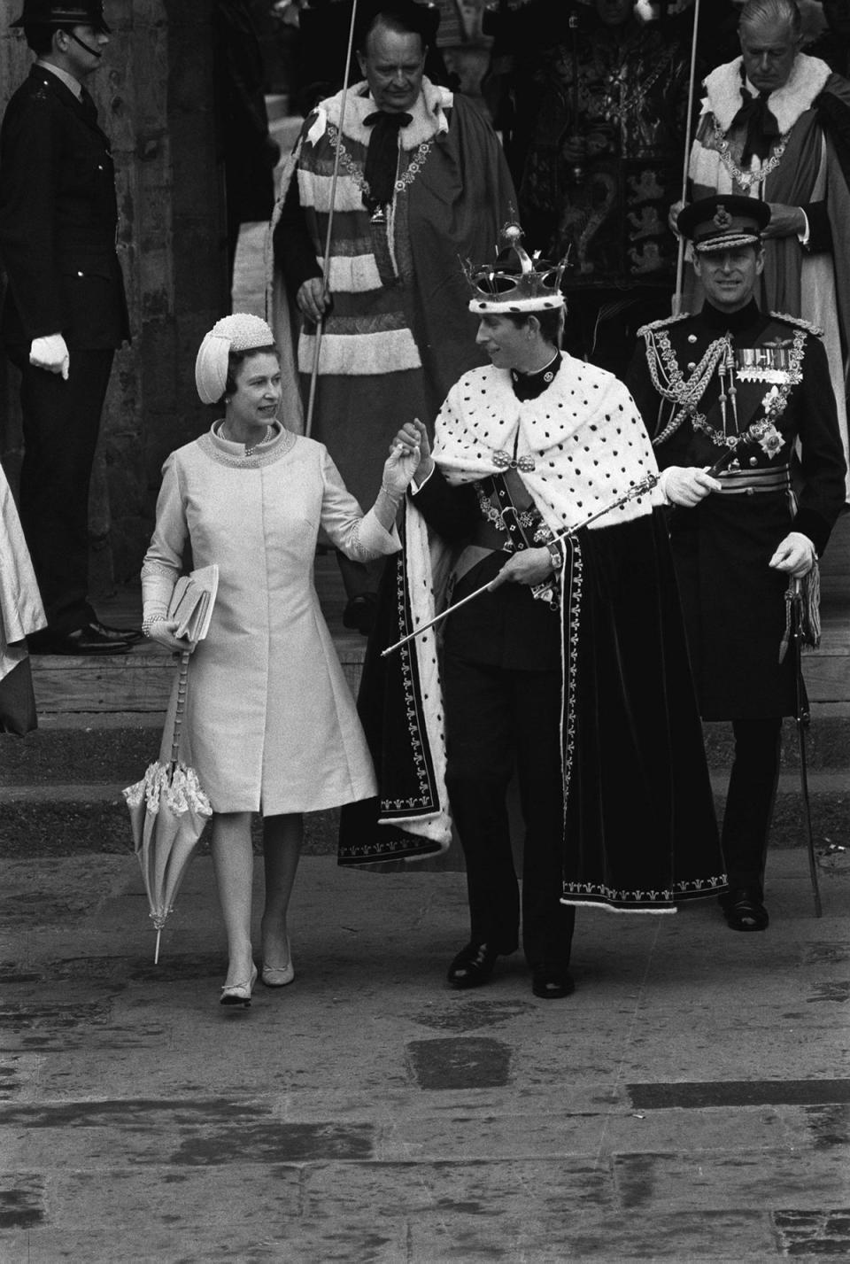 The Queen presents her son, Prince Charles, the Prince of Wales at the King's Gate at Caernarfon Castle after his investiture (PA )