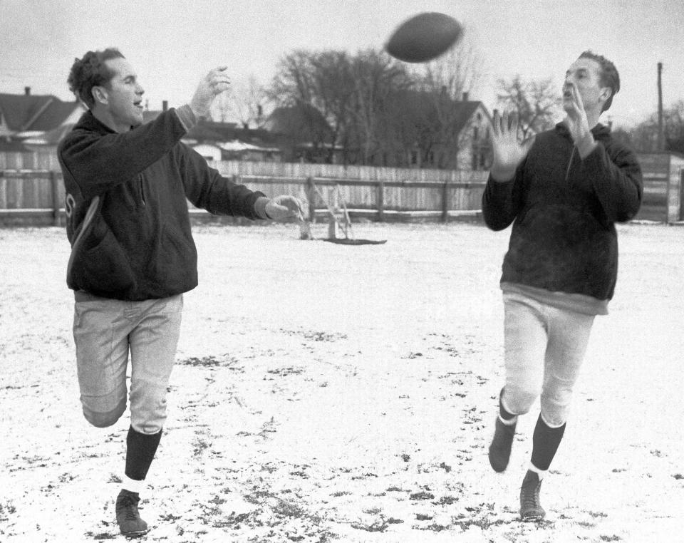 The talented passing combination of half back Cecil Isbell and End Don Hutson of the Green Bay Packers caused the Chicago Bears plenty of trouble when the teams met on Sunday, Dec. 14, 1941 in Chicago during the Western Division Playoff of the National Professional Football League.  The two Packers conditioned themselves for any weather as they practiced their famous tricks on a snow covered field at Green Bay, Wis. Isbell (left) heaves one his famous tosses to Huston.