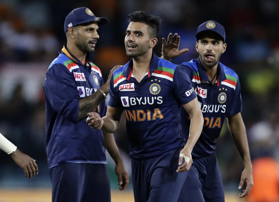 India's Deepak Chahar, center, is congratulated after taking the wicket of Australia's Moises Henriques during their T20 international cricket match at Manuka Oval, in Canberra, Australia, Friday, Dec 4, 2020. (AP Photo/Mark Baker)