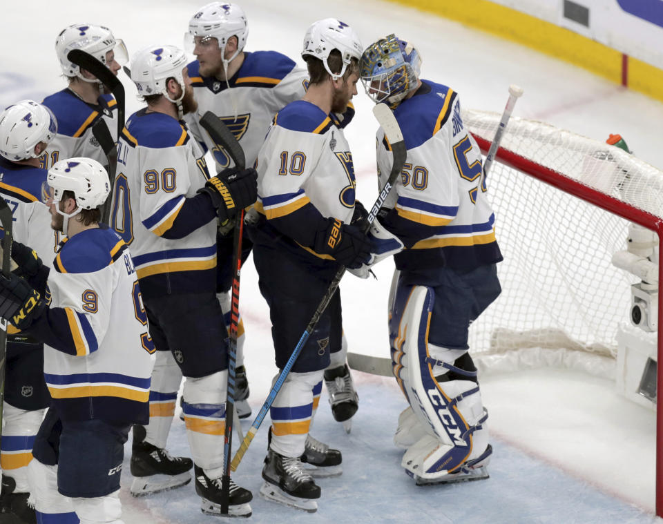 St. Louis Blues teammates congratulate goaltender Jordan Binnington, right, after defeating the Boston Bruins in Game 5 of the NHL hockey Stanley Cup Final, Thursday, June 6, 2019, in Boston. (AP Photo/Charles Krupa)