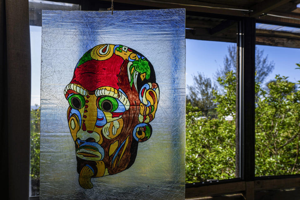 A painting by French-born artist Delphine Poulain hangs inside her home in Hanga Roa, Rapa Nui, or Easter Island, Chile, Wednesday, Nov. 23, 2022. Poulain work begins with sketches on a blank sheet. Then she takes her images to the canvas with acrylic paint. (AP Photo/Esteban Felix)